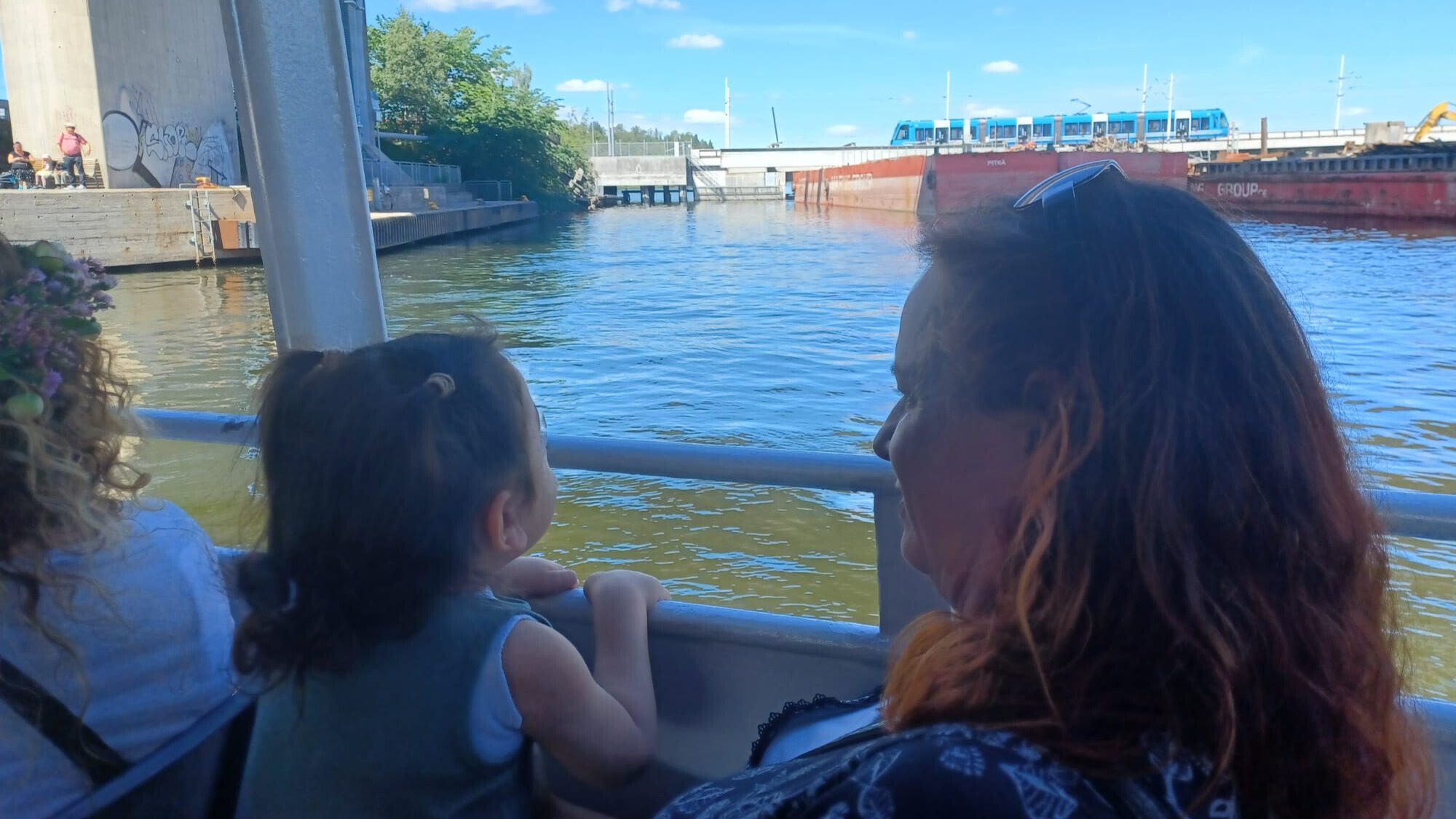 A child an an adult on a boat looking at the water